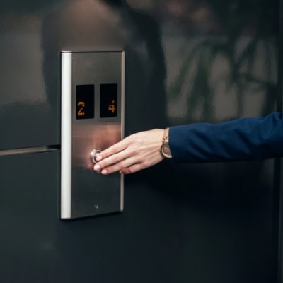 woman presses elevator button; she's on her way to a last minute meeting with the CEO or a very important client