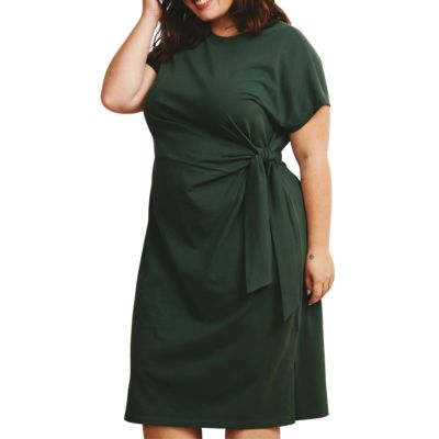 A woman wearing a dark green tie-waist dress with short sleeves