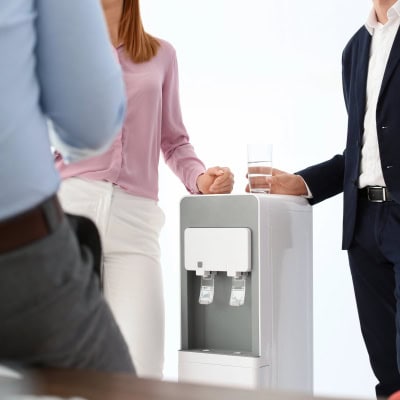 a group of colleagues gathers around the watercooler