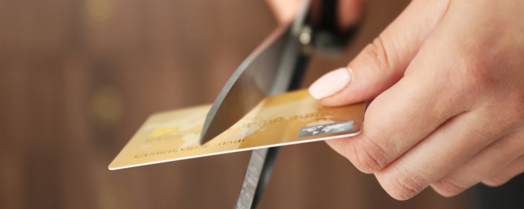 woman cuts a credit card in half