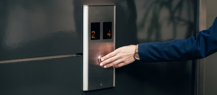 woman presses elevator button; she's on her way to a last minute meeting with the CEO or a very important client