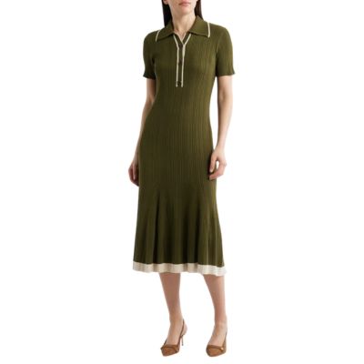 A woman wearing an olive green polo dress and brown heels