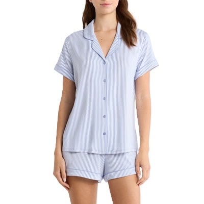 A woman (face and legs cropped out) wearing a white-and-blue striped shorts pajama set