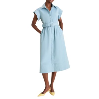 A woman wearing a light blue shirtdress with yellow kitten heels