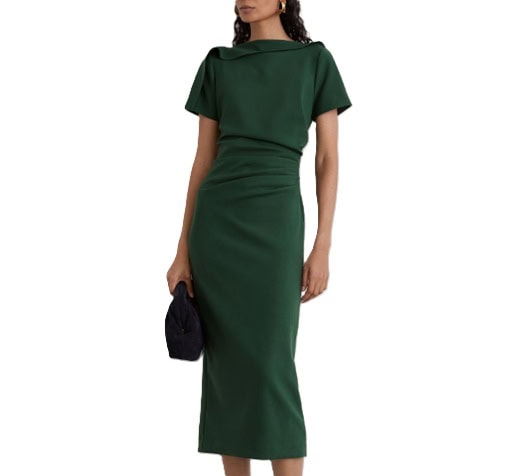 A woman wearing a dark green midi dress, carrying a black handbag