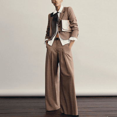 woman wears wide-leg pantsuit; her blouse is untucked and she's wearing a floppy bowtie (no comment on the bowtie)