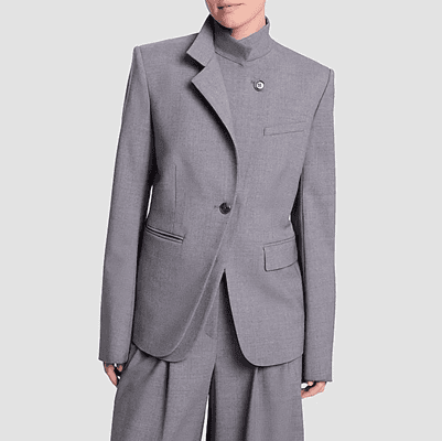 woman wears unusual blazer with two lapels, one buttons high on your neck and the other is a regular blazer lapel