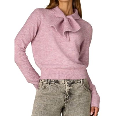 woman wears pink sweater with tie neck
