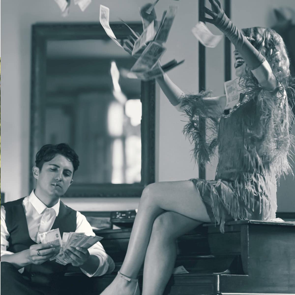 woman sits on piano in a Flapper-esque dress and throws money in the air while a man in a vest counts money below (with a toothpick in his mouth?)