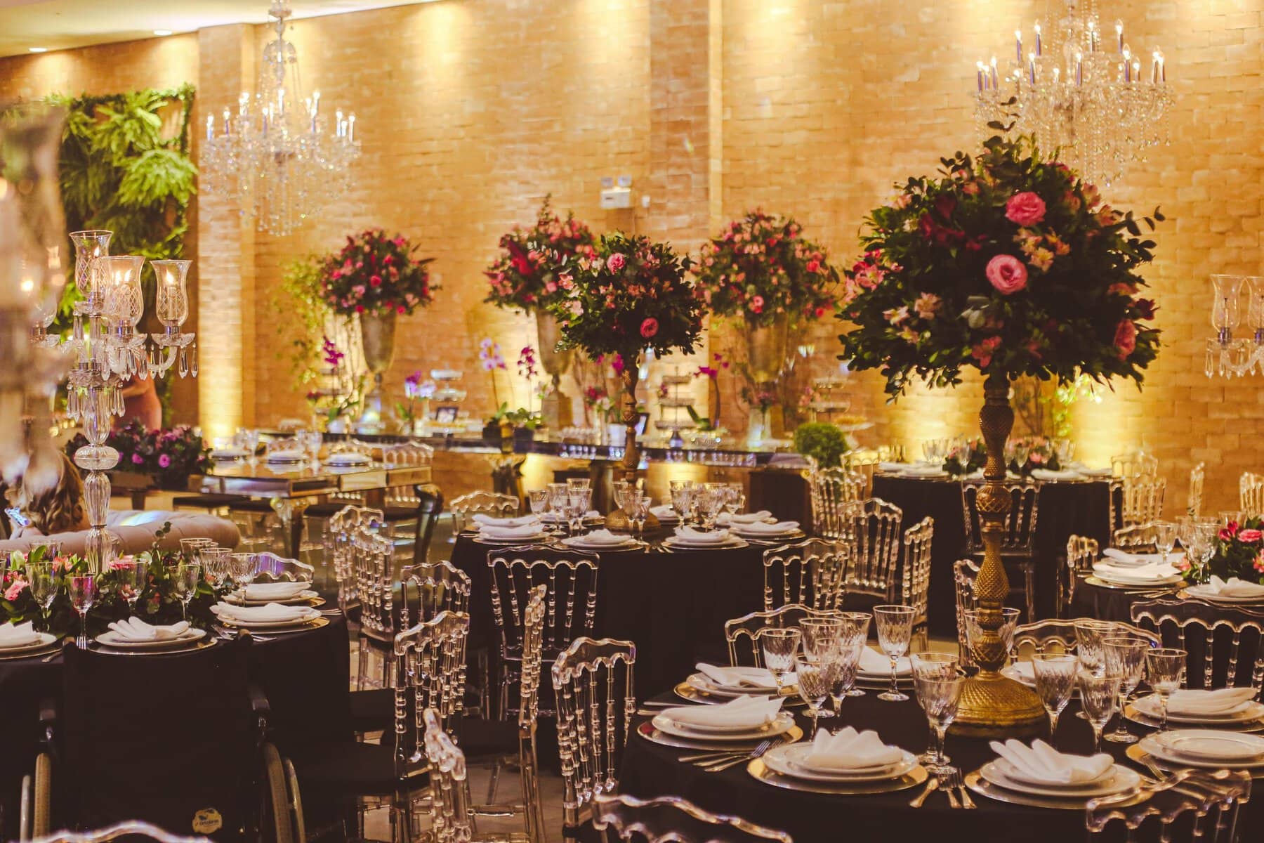 Luxurious indoor event setting with elegant floral arrangements and crystal chandeliers.