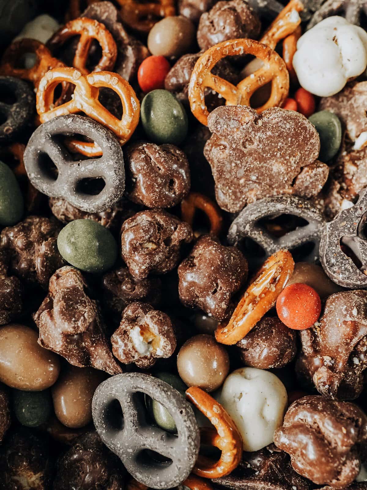 Variety of chocolate-covered snacks including pretzels and nuts in bright colors.
